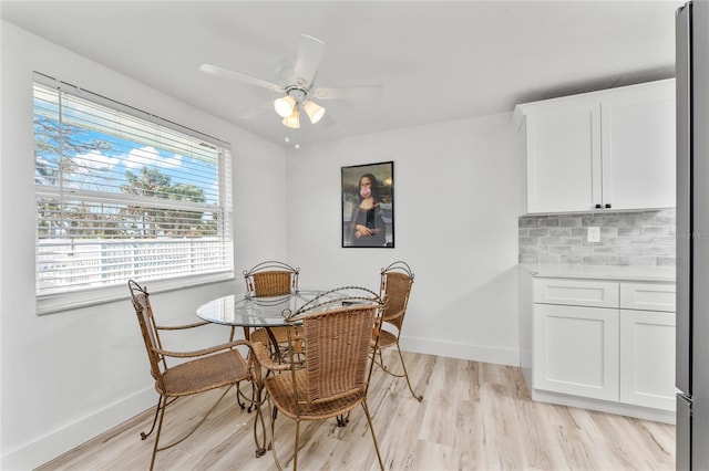 dining room with baseboards, a ceiling fan, and light wood-type flooring