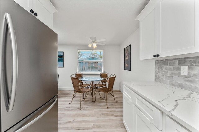 dining area featuring light wood-style flooring, baseboards, and ceiling fan