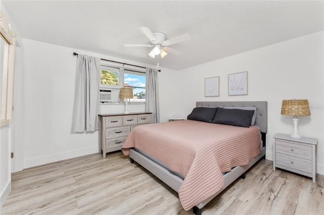 bedroom featuring cooling unit, a ceiling fan, baseboards, and light wood-style floors