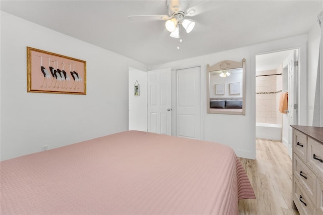 unfurnished bedroom featuring light wood-type flooring, ensuite bathroom, a closet, and a ceiling fan