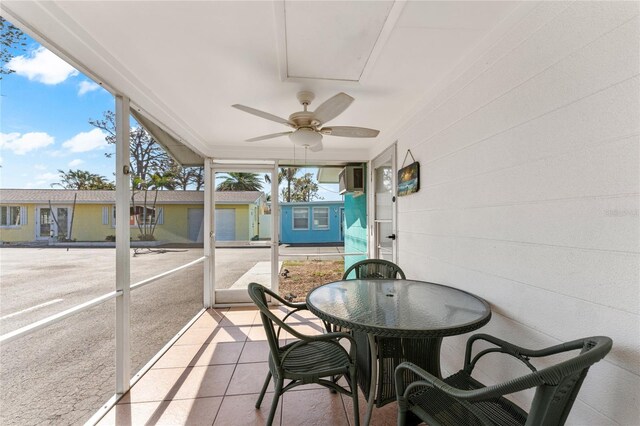 sunroom / solarium with outdoor dining area and ceiling fan