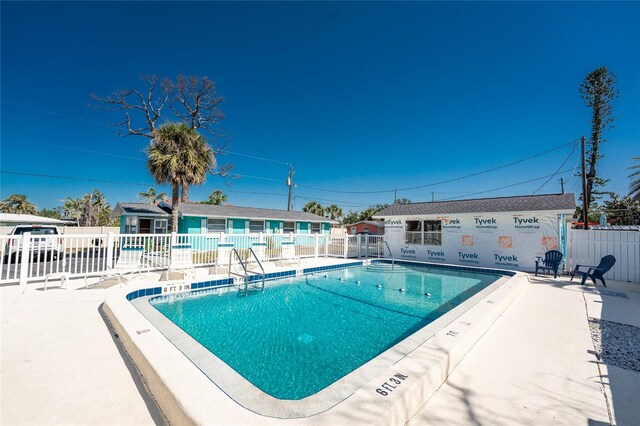 community pool featuring fence and a patio area