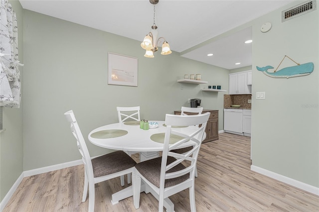 dining room with light hardwood / wood-style flooring and a notable chandelier