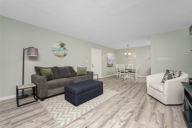 living room featuring a chandelier and light hardwood / wood-style flooring