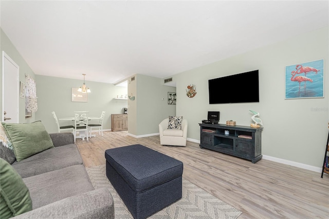 living room featuring light wood-type flooring and a chandelier