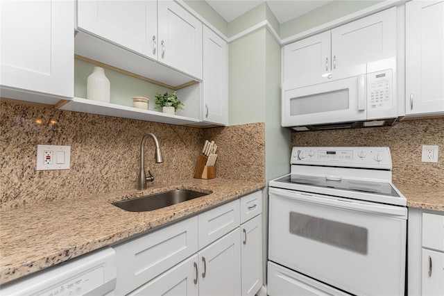 kitchen with sink, light stone countertops, white appliances, and white cabinets