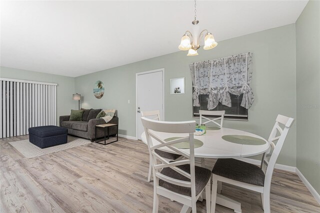 dining room with an inviting chandelier and light hardwood / wood-style flooring