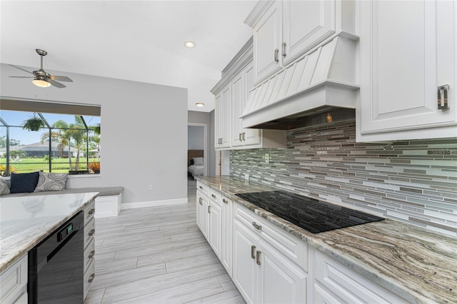 kitchen featuring light stone counters, white cabinetry, backsplash, ceiling fan, and premium range hood