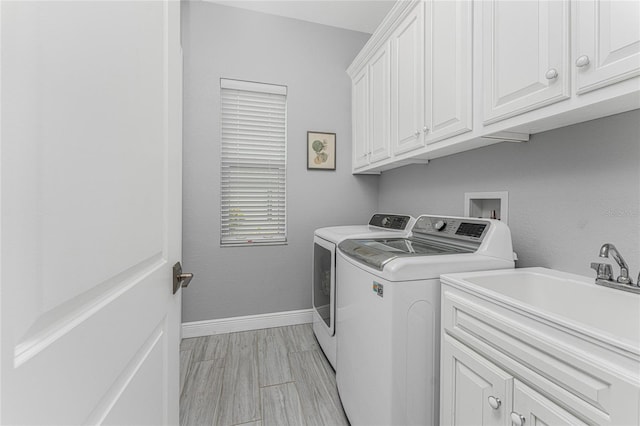 laundry room featuring cabinets, sink, and washing machine and dryer