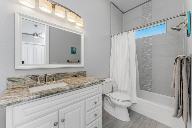 full bathroom with shower / bathtub combination with curtain, vanity, ceiling fan, hardwood / wood-style flooring, and toilet