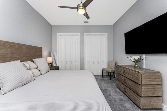 carpeted bedroom featuring multiple closets and ceiling fan