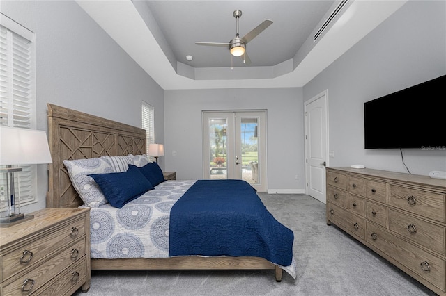 carpeted bedroom with a tray ceiling, ceiling fan, and access to exterior