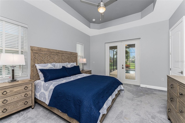 bedroom with light colored carpet, access to outside, a raised ceiling, ceiling fan, and french doors