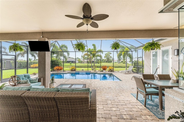 view of pool with outdoor lounge area, a lanai, ceiling fan, and a patio area