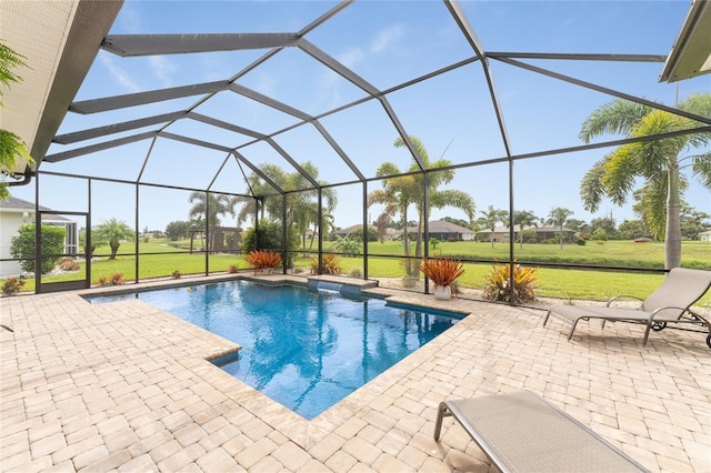 view of pool featuring a lawn, a patio area, and glass enclosure