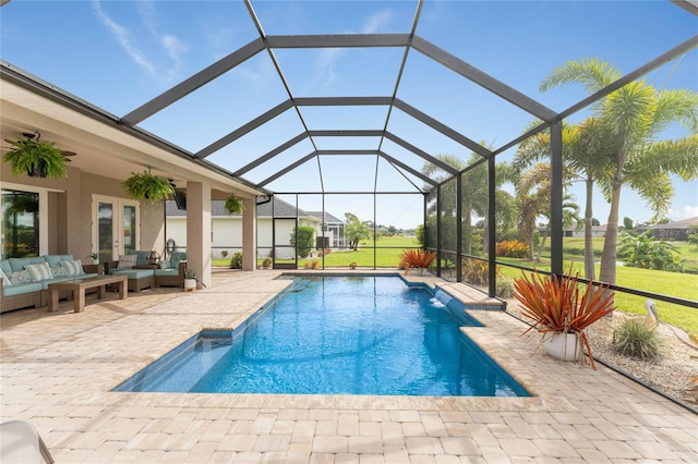 view of swimming pool featuring a lanai, outdoor lounge area, a patio area, ceiling fan, and a yard