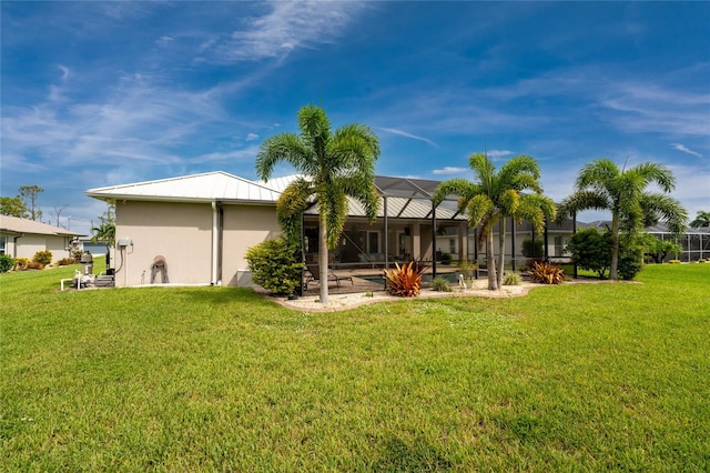 back of house with a lawn, a lanai, and a patio area