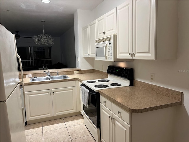 kitchen with white appliances, decorative light fixtures, a notable chandelier, light tile patterned floors, and white cabinetry