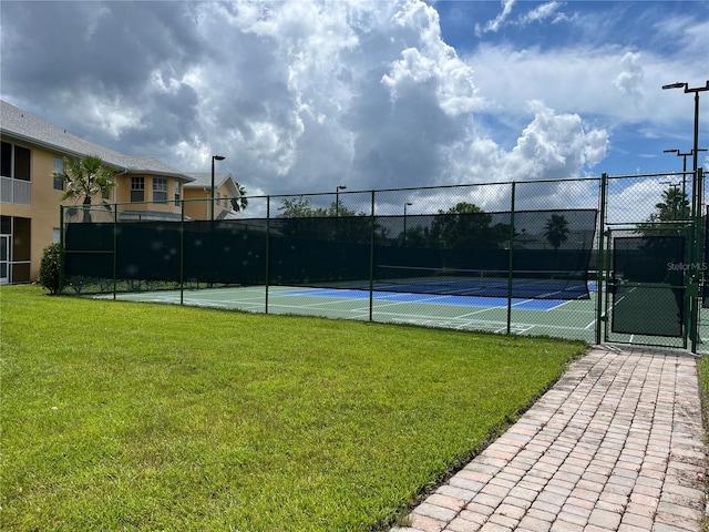 view of sport court with a lawn