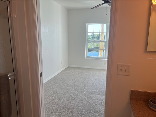 carpeted empty room featuring ceiling fan