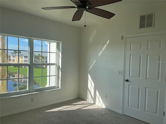 carpeted empty room featuring ceiling fan