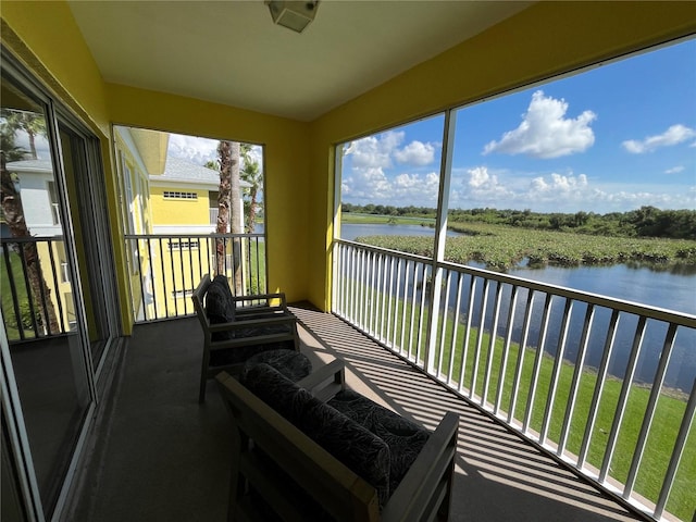 sunroom / solarium featuring a water view