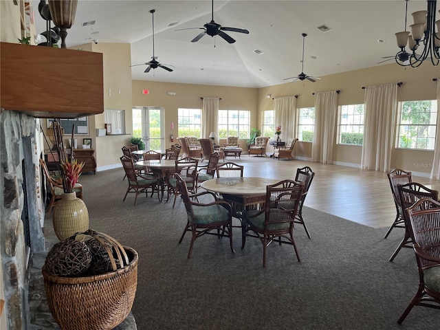 dining area featuring high vaulted ceiling, a wealth of natural light, and dark hardwood / wood-style flooring