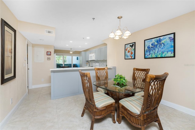 dining area featuring sink, a chandelier, and light tile patterned flooring