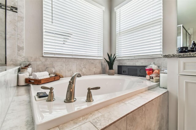 bathroom featuring a wealth of natural light and a garden tub