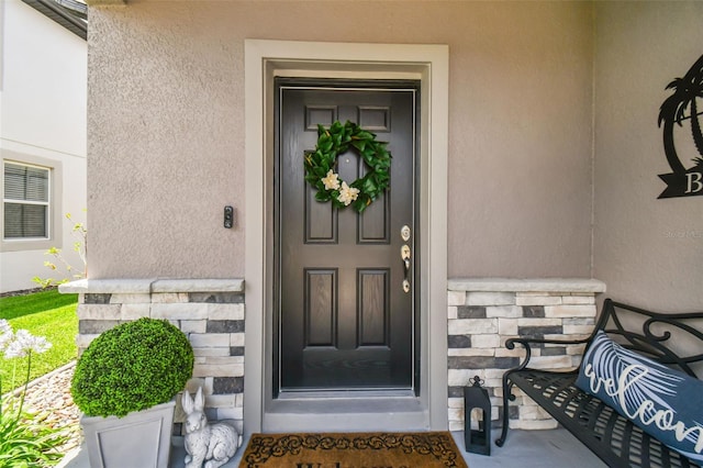 entrance to property with stone siding and stucco siding