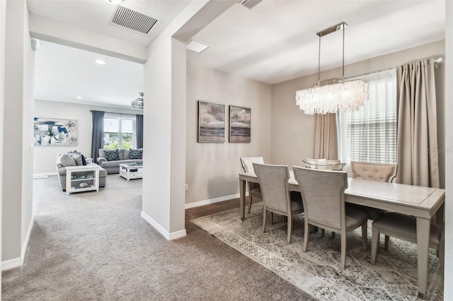 dining area featuring visible vents, baseboards, carpet, and a chandelier