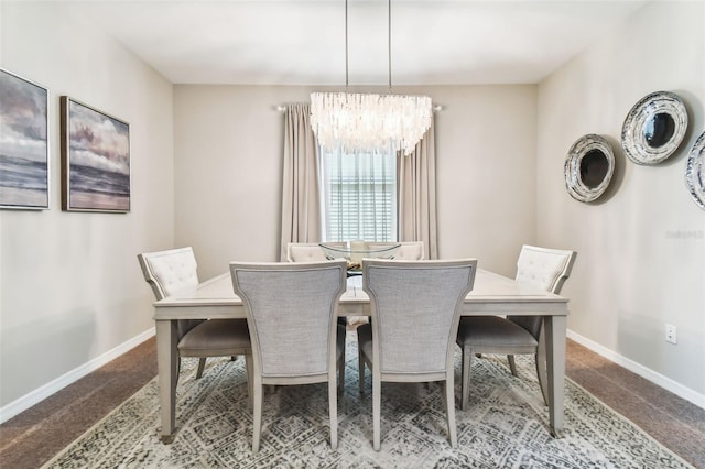 carpeted dining area featuring baseboards and a chandelier