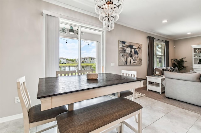 dining room with light tile patterned floors, a healthy amount of sunlight, a chandelier, and ornamental molding