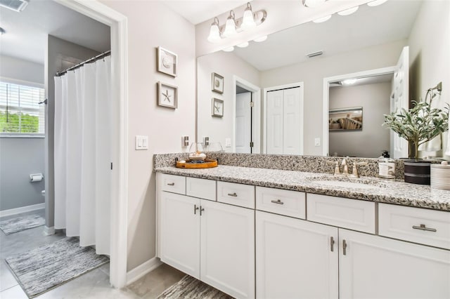 bathroom featuring visible vents, vanity, and baseboards