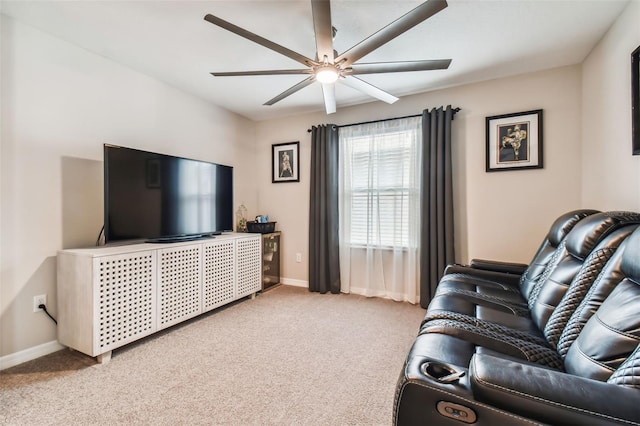 carpeted living area with a ceiling fan and baseboards