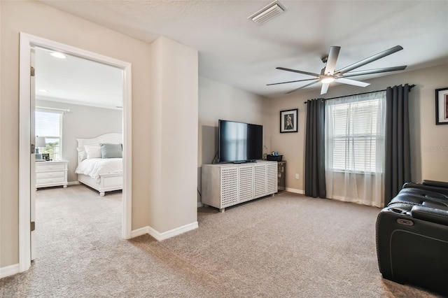 carpeted living area with visible vents, a ceiling fan, and baseboards