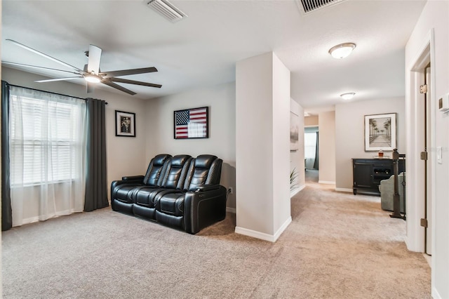 living room with visible vents, light carpet, and ceiling fan