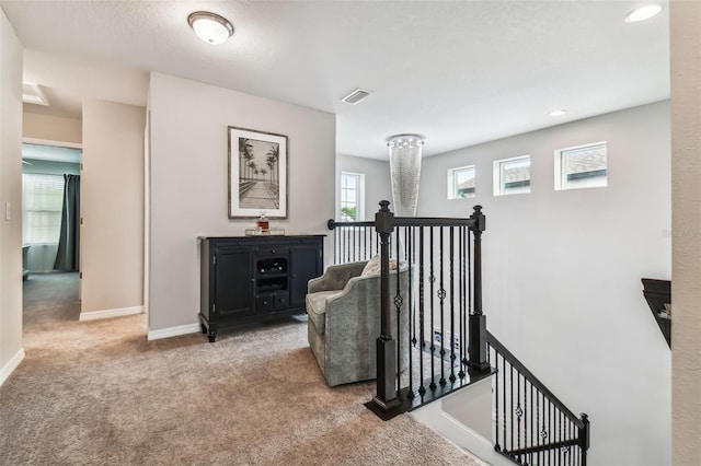 stairs featuring baseboards, visible vents, and carpet floors