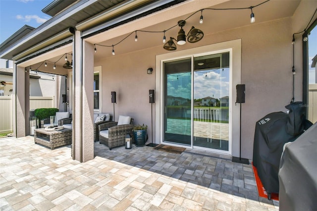 view of patio / terrace with grilling area, an outdoor living space with a fire pit, and fence