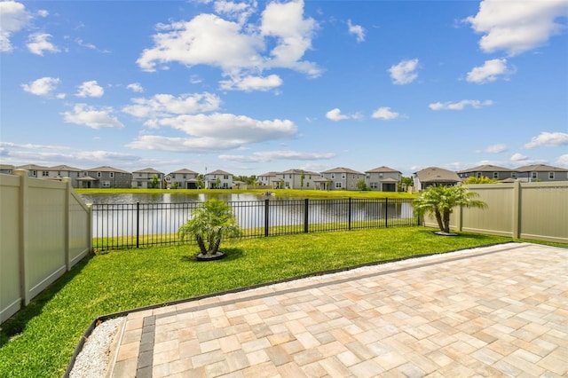 view of patio / terrace featuring a fenced backyard, a residential view, and a water view