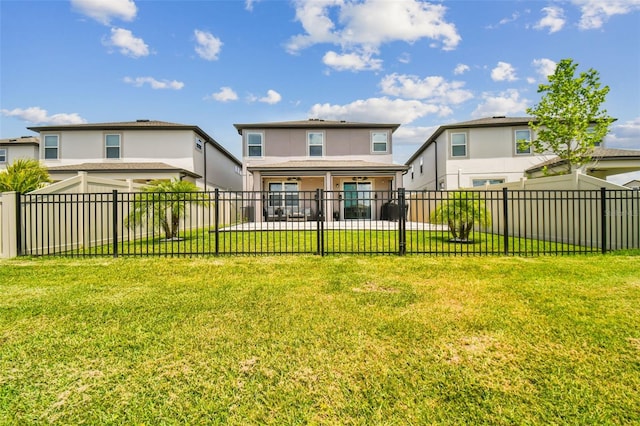 rear view of house featuring stucco siding, a patio, a lawn, and a fenced backyard