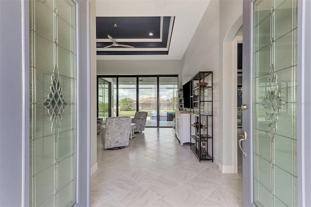 hall featuring coffered ceiling, a raised ceiling, and french doors