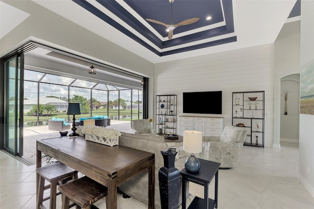 living room with a tray ceiling and a healthy amount of sunlight