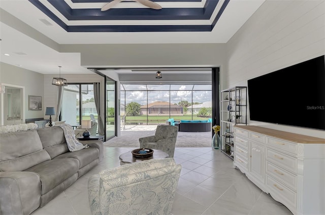 living room with a wealth of natural light and a tray ceiling