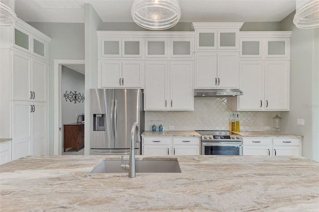 kitchen with appliances with stainless steel finishes, white cabinetry, and decorative light fixtures