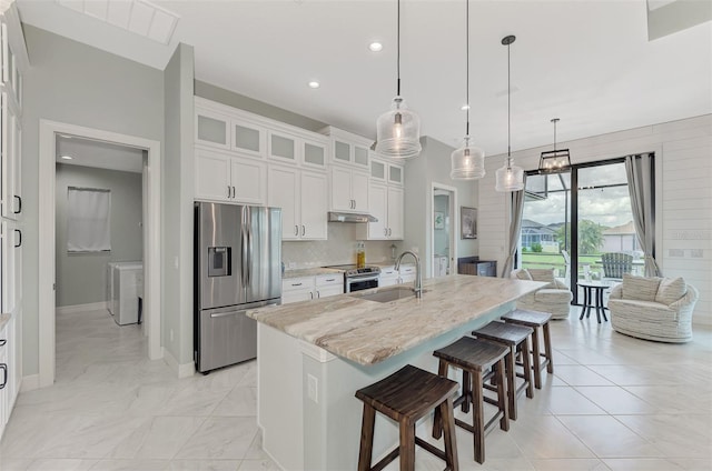 kitchen with pendant lighting, sink, a kitchen island with sink, white cabinetry, and stainless steel appliances