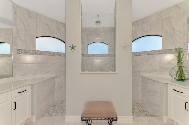 bathroom featuring vanity, tile walls, and tiled shower