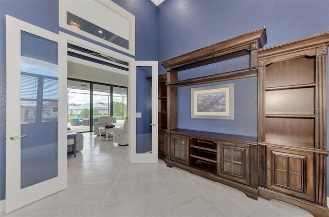 hall with french doors and light tile patterned flooring