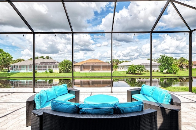 view of patio / terrace featuring an outdoor hangout area, glass enclosure, and a water view