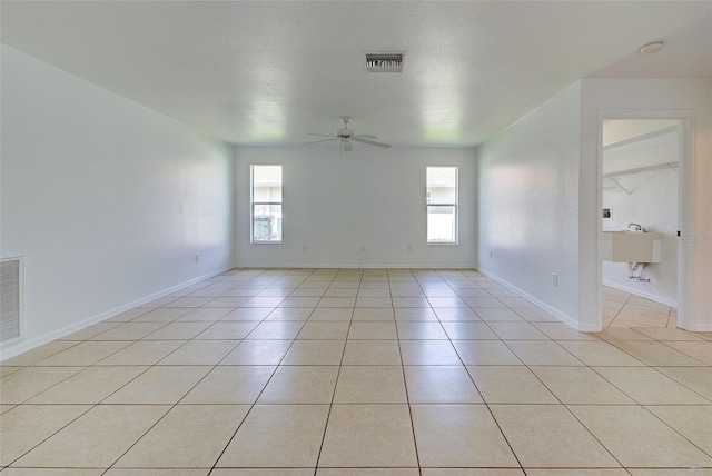 empty room featuring ceiling fan and light tile patterned floors